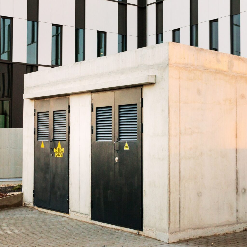 Graue Beton-Ortnetzstation, die vor einem Bürokomplex steht